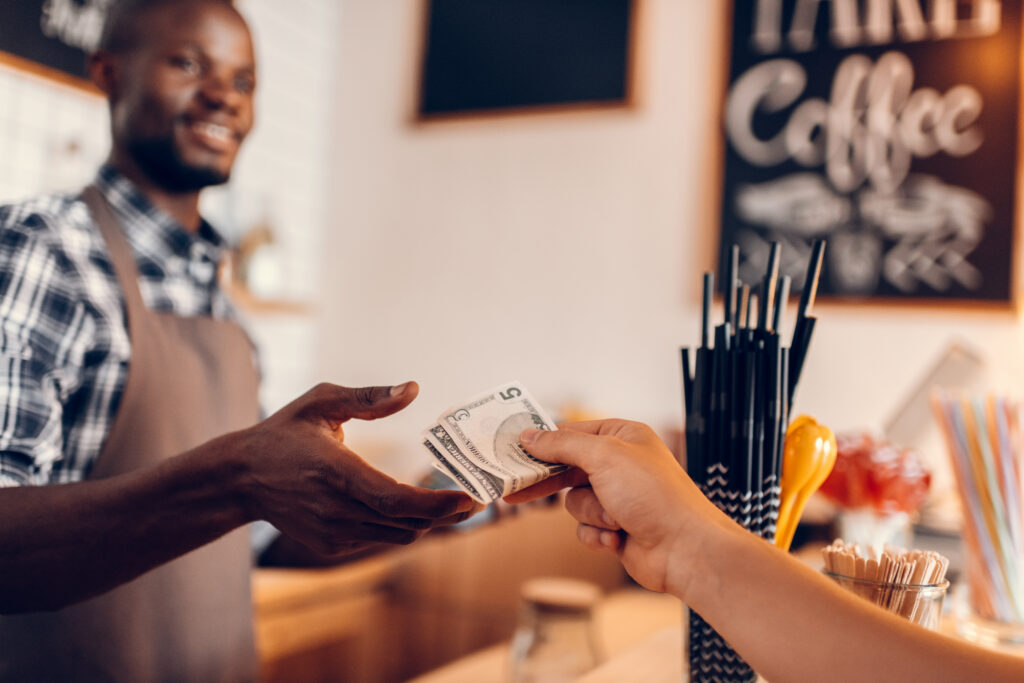 handsome smiling barista offering cash discount in cafe