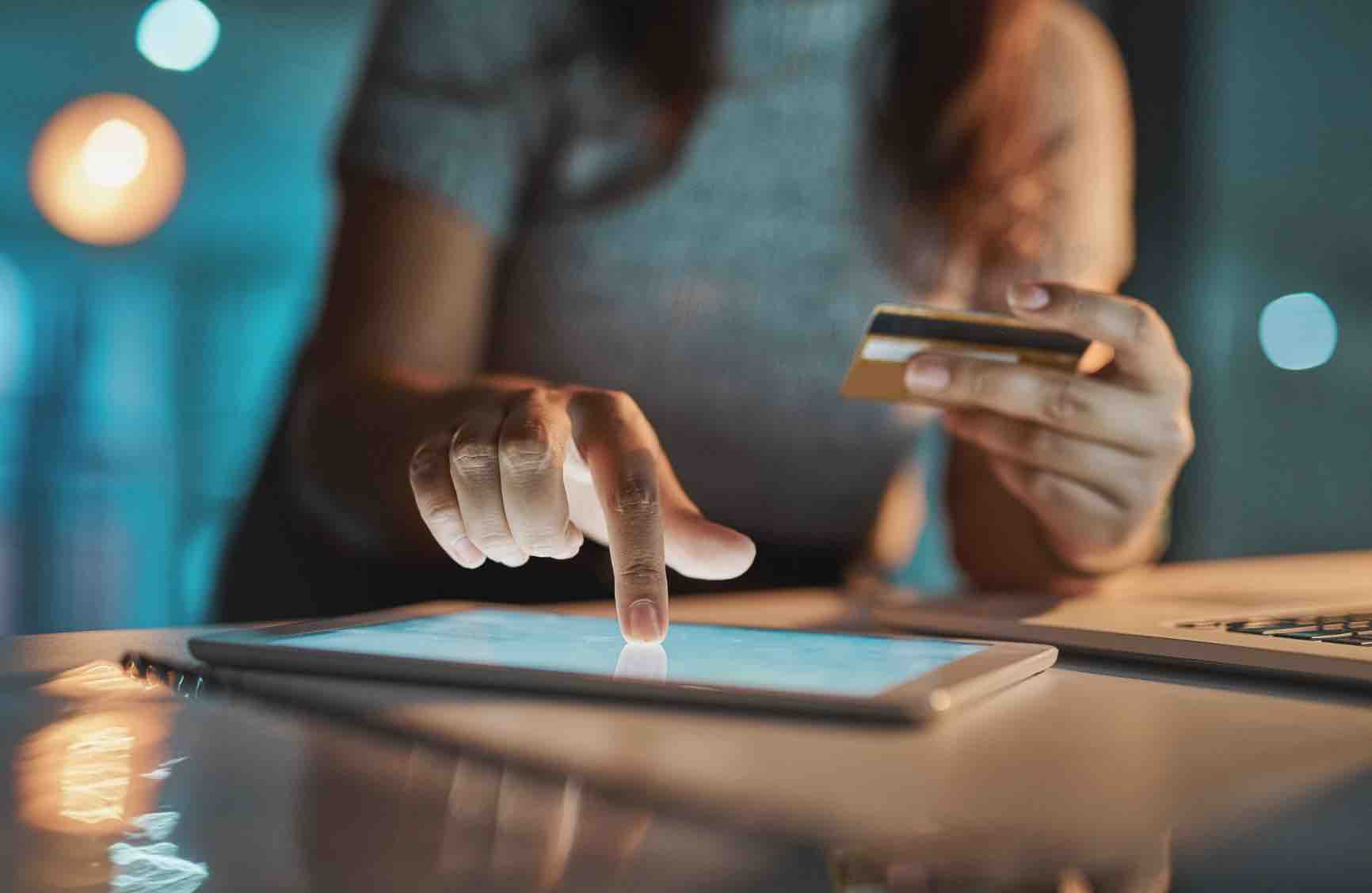 Person typing in credit card details on a tablet