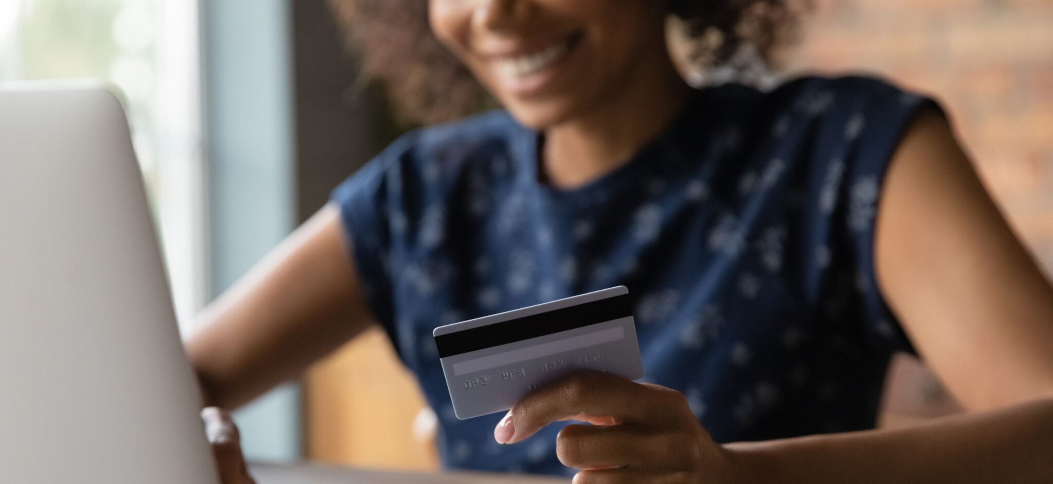 Woman entering credit card information on a laptop