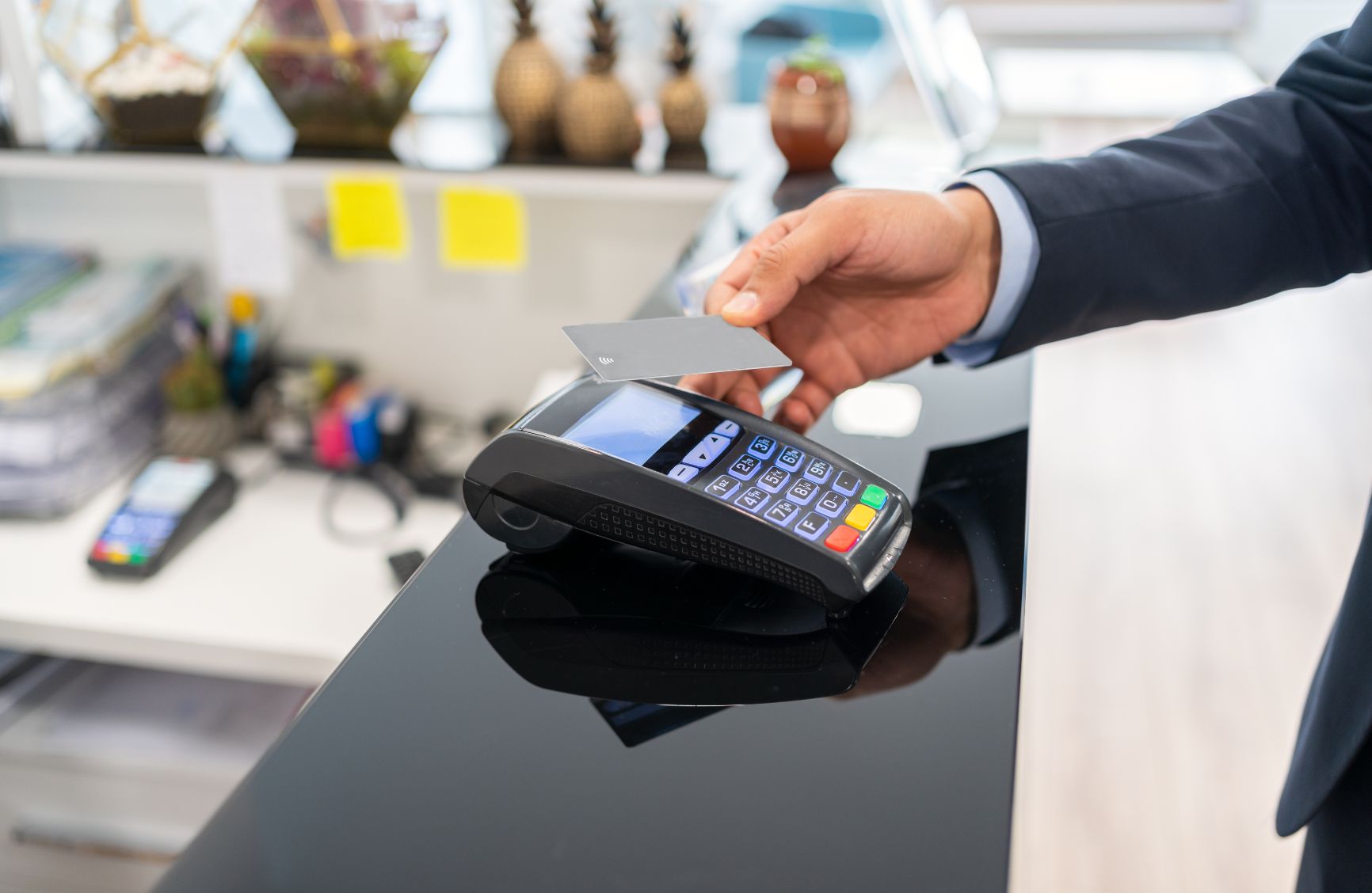 Person doing tap to pay on a payment terminal