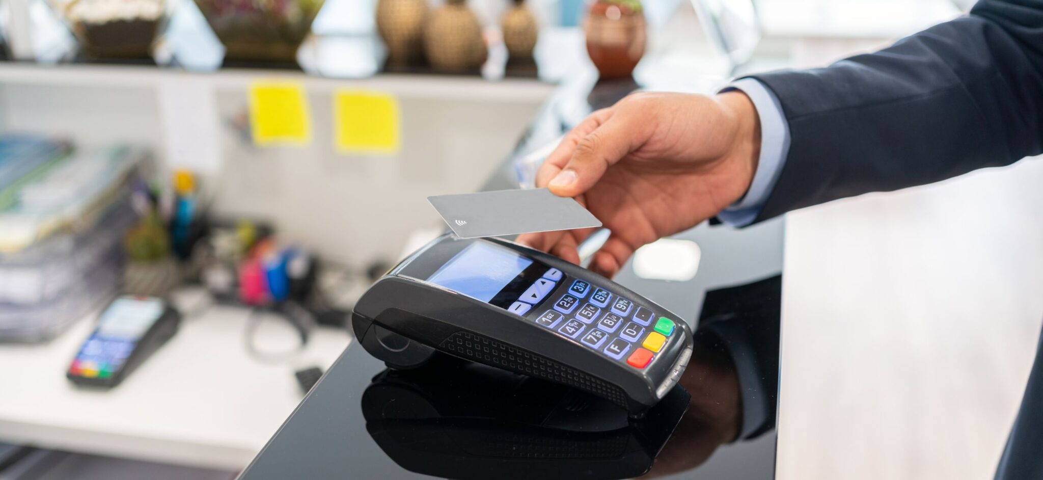 Person doing tap to pay on a payment terminal