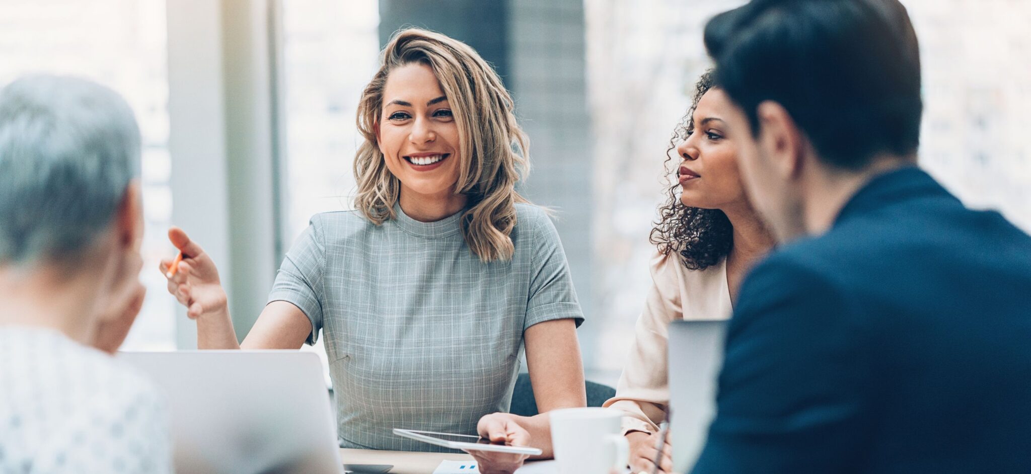 Woman speaking at a meeting in a conference room.