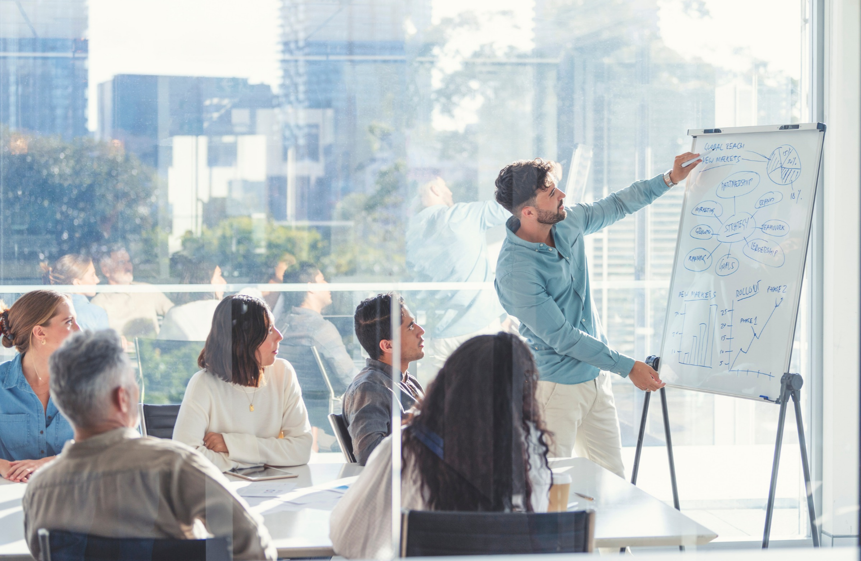 Person writing on whiteboard in conference room