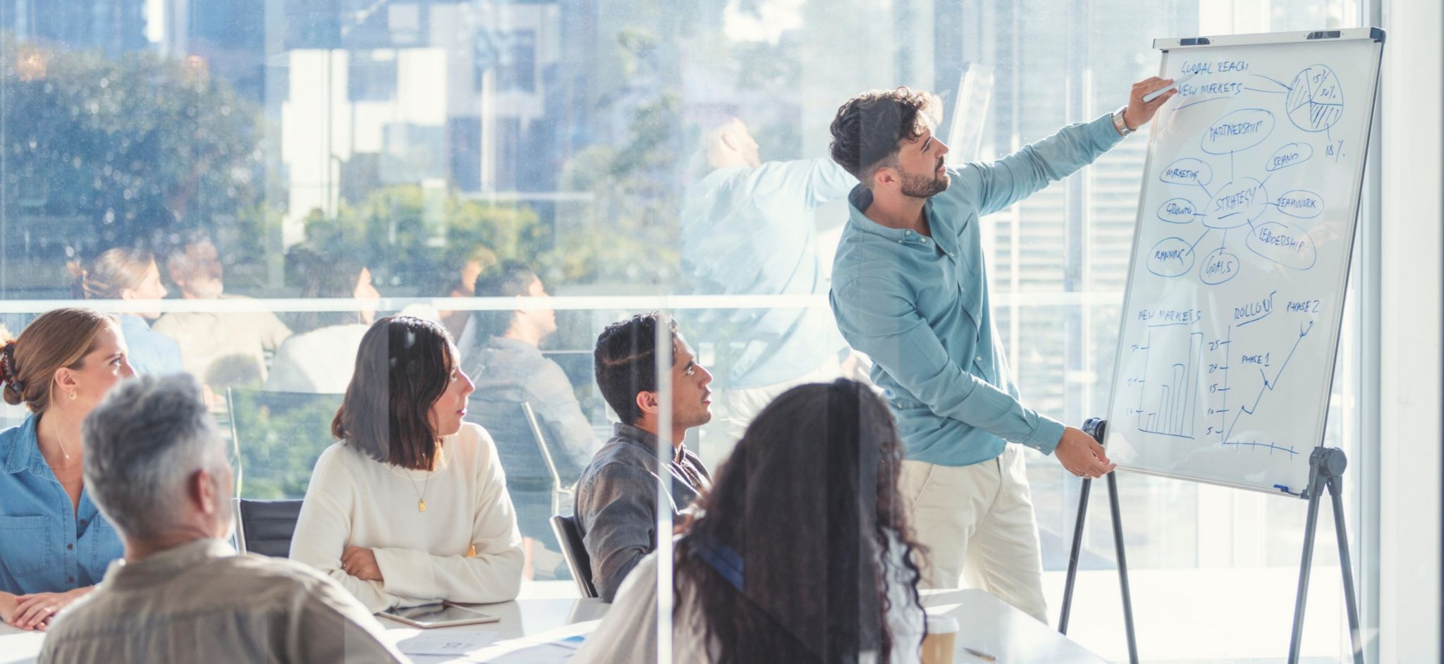 Person writing on whiteboard in conference room